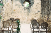 07 The ceremony space was in the Misson, with raw stone walls, refined vintage chairs decorated with greenery garlands