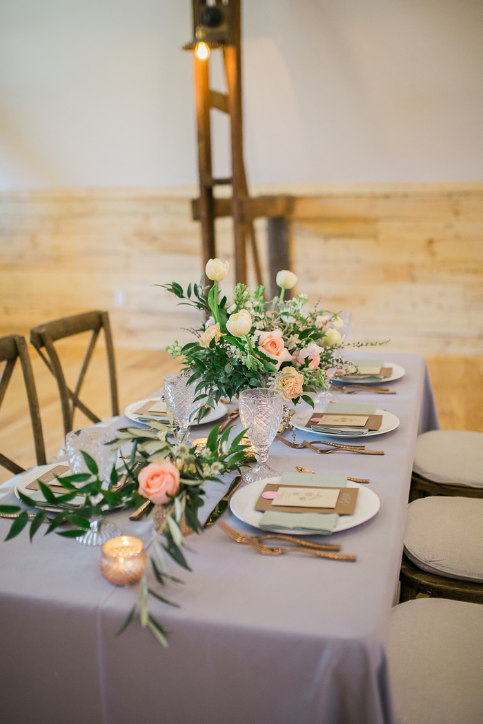 The lilac tablecloth, pastel napkins and lush peachy and pink blooms were used to style the table