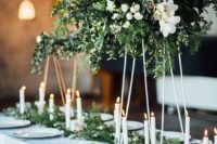 07 a gorgeous modern centerpiece with lush textural greenery, white blooms on metal stands