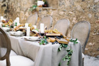 08 The wedding table was styled with a grey tablecloth and done with a runner with books, grapes, berries, candles and pears