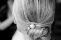 09 a super sleek low bun hairstyle with no bumps is spruced up with large pearl pins for a chic look