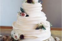10 a beautiful white ruffle wedding cake with blooms and leaves for a modern rustic wedding