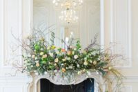 10 a fine art wedding fireplace with lush and textural greenery, branches and lush florals plus a mirror