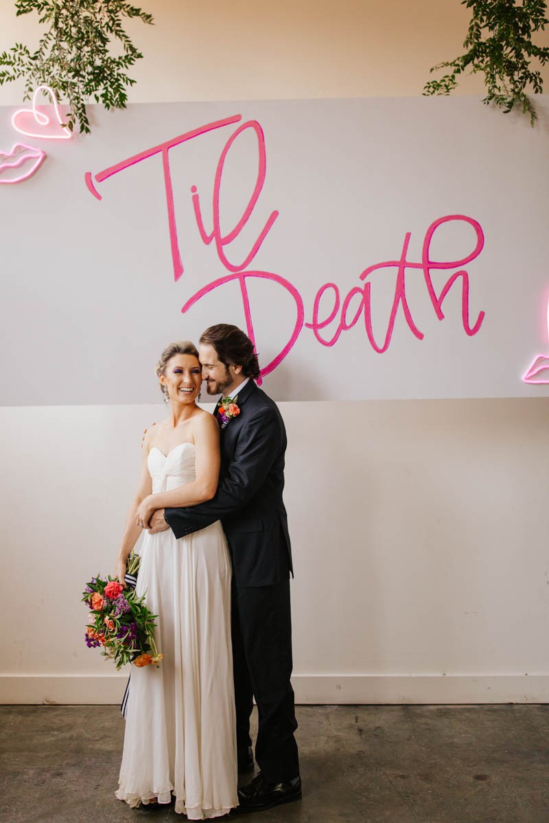 A large neon sign in pink was a great idea for a wedding backdrop