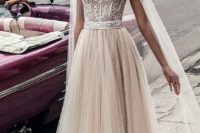 11 a beautiful nude wedding dress with a lace sweetheart neckline bodice and a pearled skirt plus a matching cape