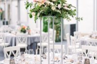 13 a modern tall centerpiece with textural greenery, pink and white flowers on a white stand