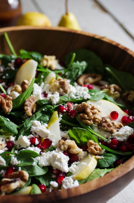 a salad with sweet pears, feta cheese, crunchy pomegranates, walnuts and spinach plus orange juice
