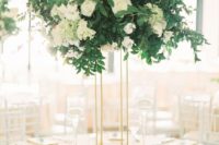 14 a stylish wedding centerpiece of white roses and hydrangeas and textural greenery on a tall thin stand