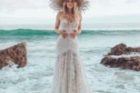 16 a boho lace strapless A-line wedding gown paired with a straw hat for an island or destination bride