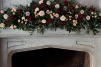 16 a vintage fireplace with candles, a real fire and a very lush floral decoration with greenery