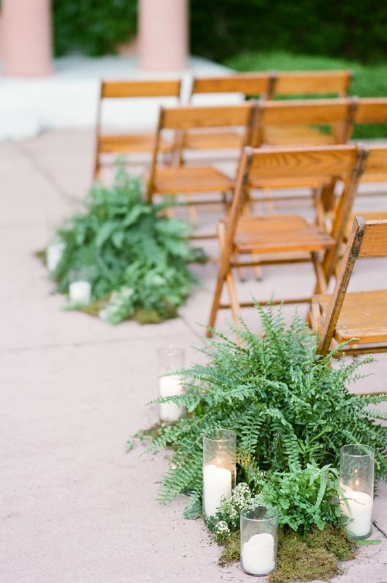 a wedding aisle with moss, ferns and candles for a natural touch, these plants won't wilter