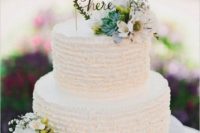 17 a white ruffle wedding cake decorated with succulents, neutral blooms and a calligraphy topper