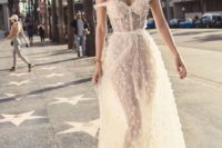 18 a blush semi sheer off the shoulder wedding dress with lace appliques and a bustier bodice
