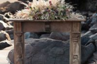 19 a faux boho wooden mantel topped with blooms, pampas grass and feathers for a boho feel