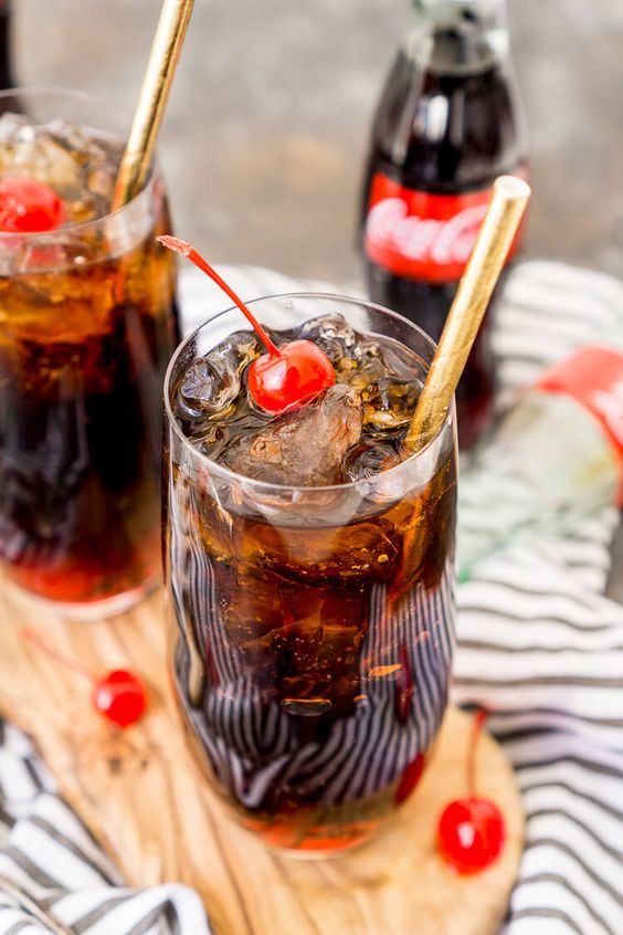 a Coca Cola cocktail topped with cherries as a cool nonalcoholic alternative