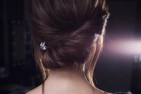 20 a low asymmetrical twisted chignon with a bump, some locks down and a rhinestone hairpiece for an accent