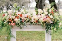 21 a floral arbor mantel with lush blooms and cascading greenery for a chic and elegant feel