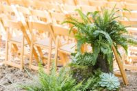 21 decorate the wedding aisle with lush ferns and large succulents displayed on tree stumps