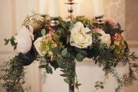 22 a luxurious tall candelabra centerpiece with candles, blush and neutral blooms and cascading greenery