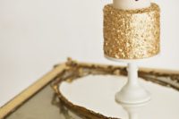 23 a chic wedding cake with a gold sequin layer and fresh flowers on top for a fall wedding