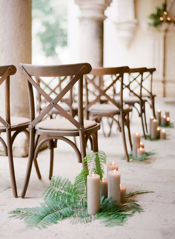 ferns placed on the floor and taupe candles placed right on them look natural and fresh