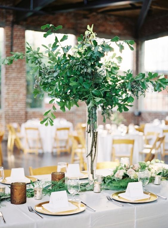 a chic lush greenery wedding centerpiece with a clear vase and a matching greenery runner