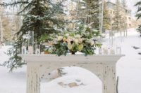 24 a shabby chic white mantel with candles, a lush pale centerpiece with greenery and firewood inside