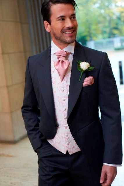 a chic black morning suit, a pink printed waistcoat and a pink cravat tie for a formal look