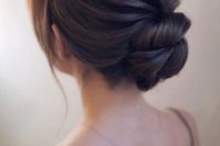 25 an elegant twisted low bun with a textural and voluminous bump and locks to frame the face
