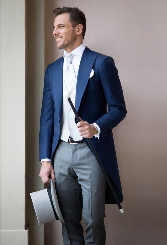 a gorgeous morning suit with a navy blazer and grey pants, a white wiastcoat and shirt plus a white cravat