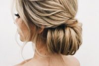 26 an oversized low bun with a twisted braid on the side and some waves down for a refined feel