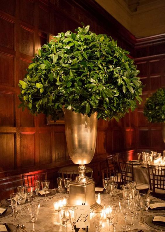 a tall leafy centerpiece in a large gold vase is all you need for modern rustic elegant at the table