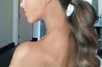 a beautiful and elegant wavy low ponytail with a sleek and shiny top is a stylsih idea for a glam look