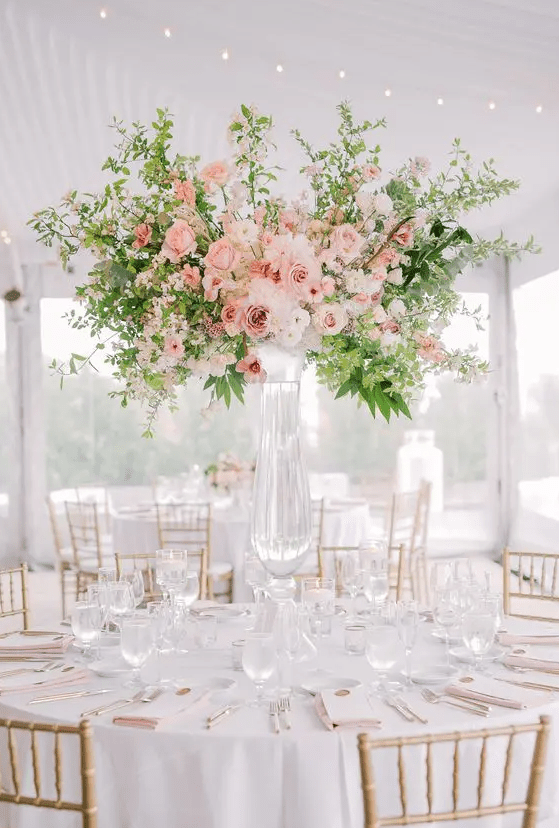 a beautiful and sophisticated tall floral wedding centerpiece with white, blush and peachy blooms and greenery is a lovely idea for spring or summer
