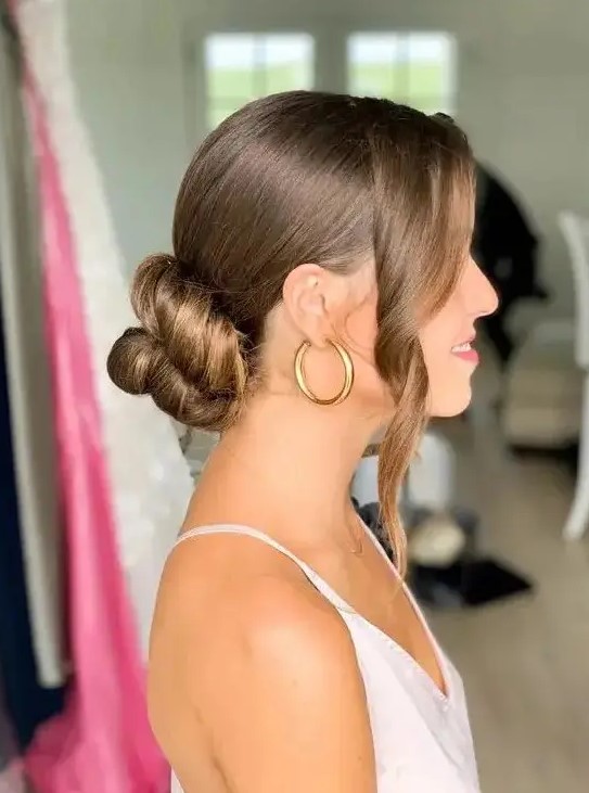 a beautiful twisted low bun with a sleek top and some wavy locks framing the face is a cool and chic idea to rock