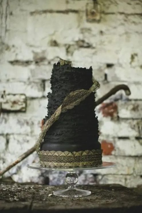 a black textural wedding cake with gold lace is a cool moody wedding dessert to try