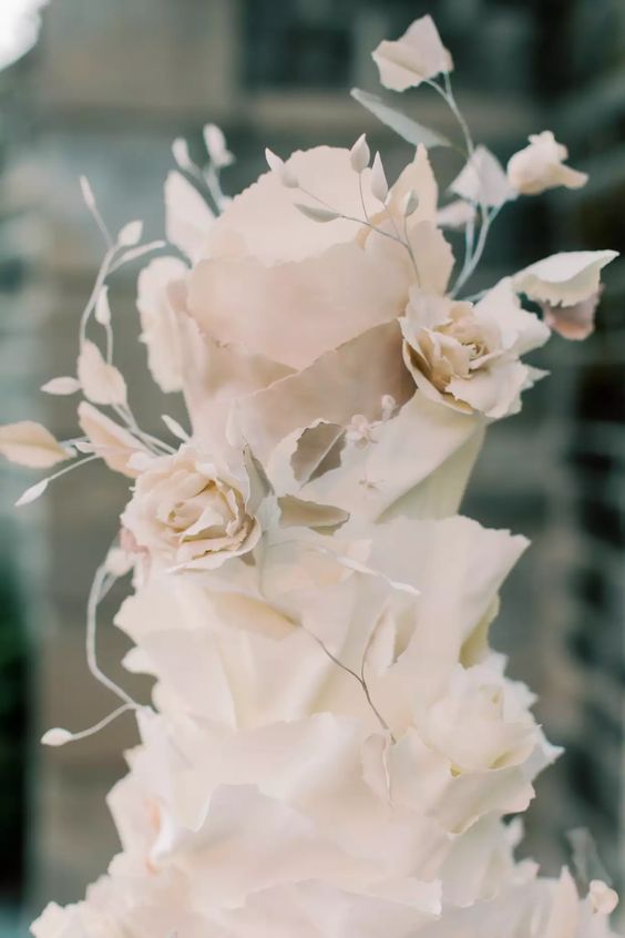 a blush ruffle wedding cake with sugar blooms and leaves looks very exquisite, chic and gorgeous