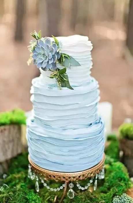 A buttercream ombre blue wedding cake with a large succulent on top and some greenery is a great idea for a vintage inspired wedding