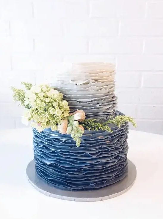 A chic ombre blue wedding cake decorated with real blooms and greenery is a lovely solution for a vintage inspired wedding