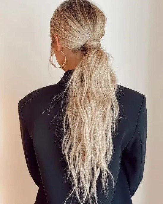 a classy messy and textural low ponytail with a messy top and hair wrapping it is a cool idea for a modern look