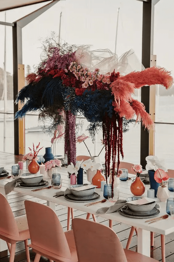 a colorful fresh and dried flower installation hanging over the table is a pretty idea to rock