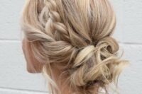 a cool messy and curly low updo with a braided halo and some locks and curls down for a boho or rustic wedding