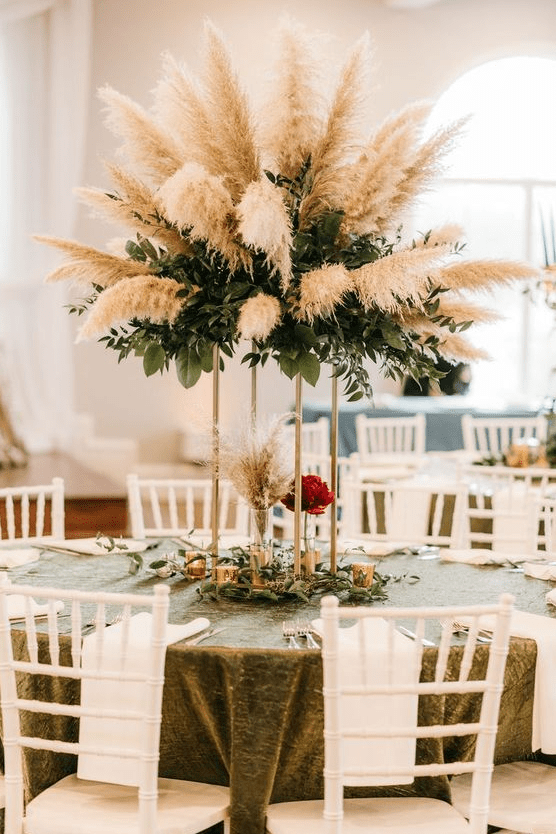 a dramatic wedding centerpiece of textural greenery and pampas grass is a pretty and bold idea for a modern wedding