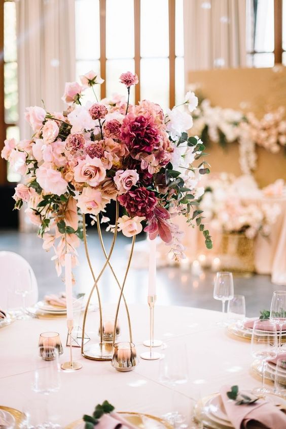 a fab tall wedding centerpiece in pink shades, with blush, light pink and mauve blooms and greenery