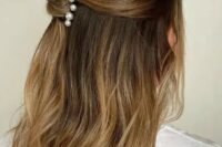 a lovely half updo with a bump on top and a twist accented with pearl hair pins is good for medium and long hair