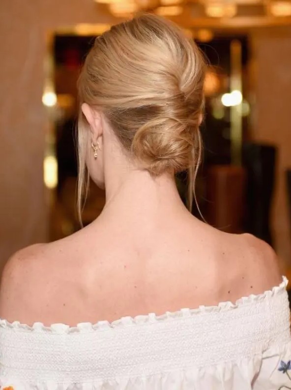 a low French twisted updo with a volume on top and locks down is a stylish idea for a effortlessly chic look