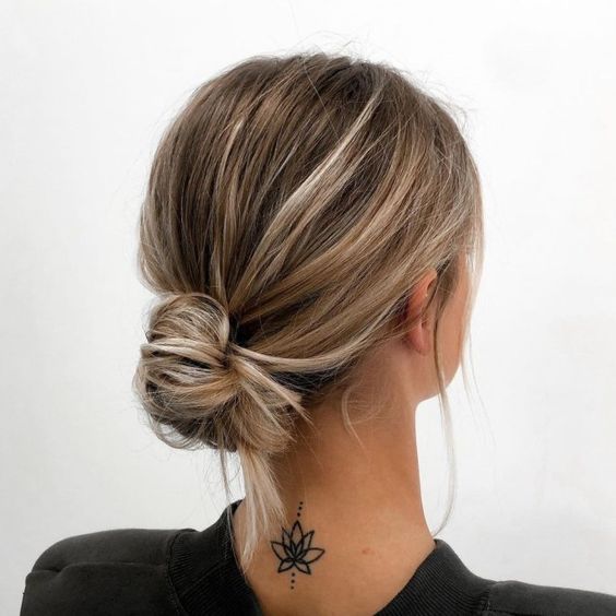 a messy low bun with a bump on top and some hair down is a chic and simple idea for a casual wedding guest look