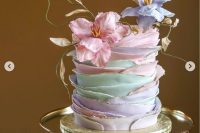 a pastel ruffle wedding cake with a gold edge and pastel blooms is a chic and cool idea for a spring wedding