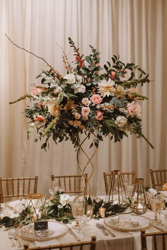 a pretty tall wedding centerpiece of white and pink blooms, greenery and berries and some twigs is a cool idea for an elegant summer wedding
