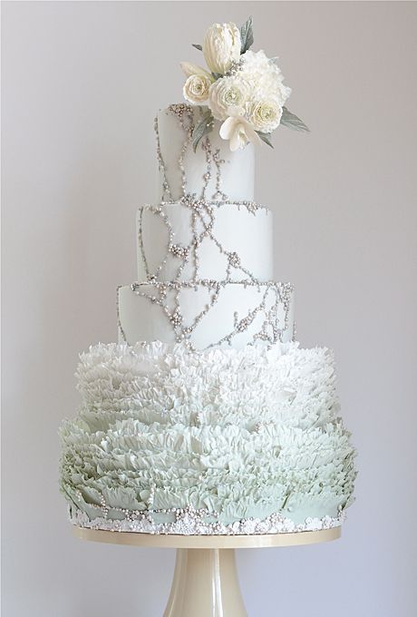 a refined pale green and white ruffle wedding cake with edible beads and white blooms on top is amazing for spring